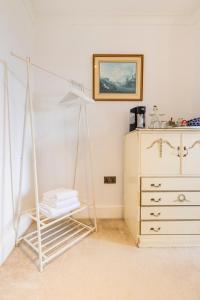 a white room with a bed and a dresser at Penyvoel Hall in Llanymynech