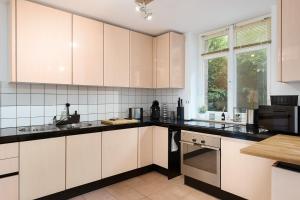 una cocina con armarios blancos y encimeras negras en EasyWood modernes Apartment 4P by EasyHood, en Nottuln