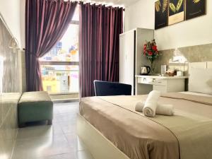- une chambre avec un lit, un bureau et une fenêtre dans l'établissement Saigon Cozy Hotel, à Hô-Chi-Minh-Ville