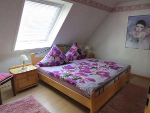 Un dormitorio con una cama con sábanas moradas y una ventana en Ferienwohnung Yuan, en Bruchweiler-Bärenbach
