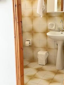a bathroom with a sink and a toilet at wave rooms sea view in Chania