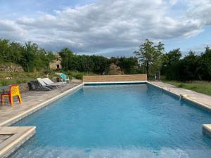 een groot zwembad met blauw water in een tuin bij Gîte à la Ruelle "Pierre et Mamie" ! in Savignac-de-Miremont