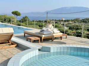 a patio with a bench and a table next to a pool at Lithies Sea View Boutique Hotel in Koríthion