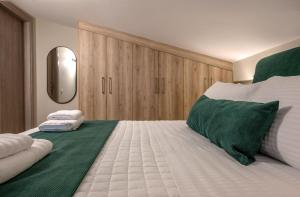 a bedroom with a large bed with green and white at NK Luxury Apartments in Preveza