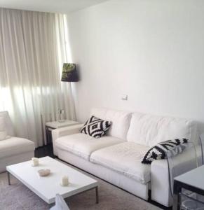 sala de estar con sofá blanco y mesa en Apartamento Paco, en Playa del Inglés