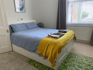 a bedroom with a bed with a yellow blanket on it at Elegant Spacious Apartment in Heart of St Leonards in Hastings