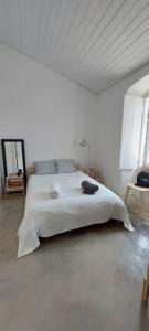 ein weißes Schlafzimmer mit einem großen weißen Bett in einem Zimmer in der Unterkunft Casa d´Abela in Abela