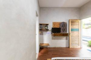 ein Wohnzimmer mit weißen Wänden und Holzböden in der Unterkunft Surfer Garden in Sanur