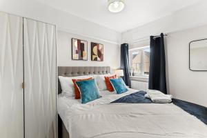 um quarto com uma cama grande e almofadas azuis em Stunning Norwich Gem Sleeps 7 - Parking - Garden em Earlham