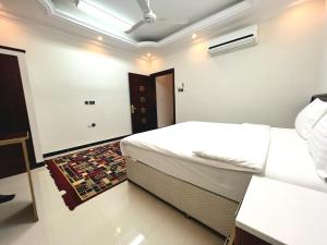 a bedroom with two white beds and a door at Al Taraf Hotel Apartment in Sur