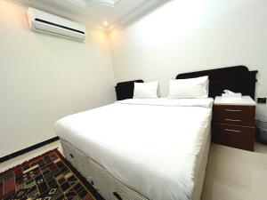 Al Taraf Hotel Apartment في صور: غرفة نوم بسرير ابيض كبير ومكيف