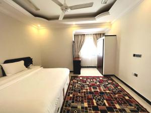 Al Taraf Hotel Apartment في صور: غرفه فندقيه بسرير ونافذه