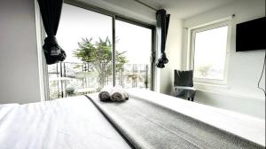 una camera da letto con un letto bianco e una grande finestra di The pacific Hotel a Clacton-on-Sea