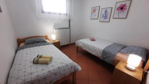 due letti in una piccola stanza con due lampade di Apartment Pergola with Mediterranean Garden & BBQ a Portoroz