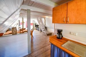 een keuken en een woonkamer met een trap in een tiny house bij Nordic Ferienpark Sorpesee in Sundern