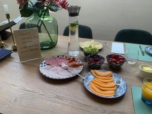 einen Tisch mit Teller mit Lebensmitteln und Schalen mit Früchten in der Unterkunft Annense Pracht in Annen