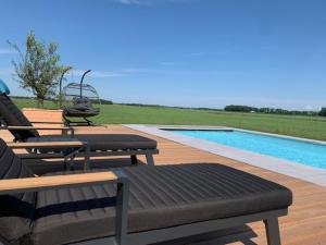 un patio avec deux bancs et une piscine dans l'établissement Annense Pracht, à Annen