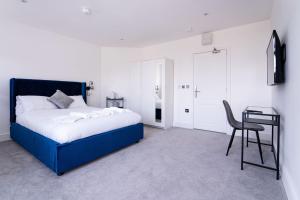 - une chambre avec un lit bleu, une chaise et une table dans l'établissement Woodman Pub, à Londres