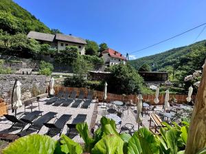 eine Gruppe von Stühlen und Sonnenschirmen im Innenhof in der Unterkunft Bajta Kroparica in Kropa