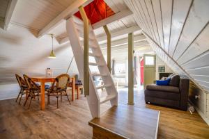 uma sala de estar com uma escada numa pequena casa em Nordic Ferienpark Sorpesee em Sundern