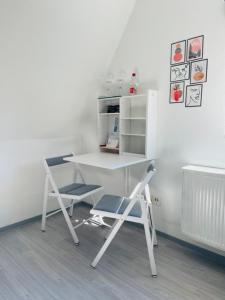 un escritorio blanco y 2 sillas en una habitación en Tolle Wohnung in bester Lage von Heidenheim, en Heidenheim an der Brenz