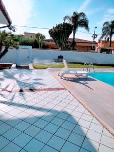 una piscina con sedia bianca accanto a una piscina di La casa di Elisa villa con piscina a San Leone