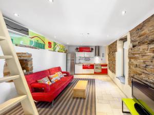 ein Wohnzimmer mit einem roten Sofa und einer Küche in der Unterkunft Ikaria View Resort and Villa with Pool in Arethousa