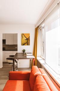 uma sala de estar com um sofá laranja e uma mesa em Silversant Zeezicht em Oostende