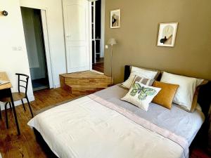 1 dormitorio con 1 cama con sábanas y almohadas blancas en Confortable 2 pièces au cœur de dreux #2, en Dreux