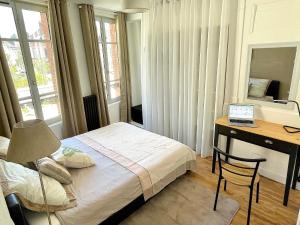 a bedroom with a bed and a desk with a laptop at Confortable 2 pièces au cœur de dreux #2 in Dreux