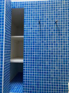 a blue tiled wall with a shelf in a bathroom at Petite maison quartier hist in Collioure