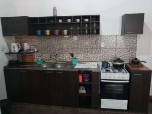 uma cozinha com um fogão e uma bancada em La casa de MaCa em Posadas