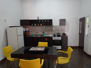 a kitchen with a dining table and yellow chairs at La casa de MaCa in Posadas