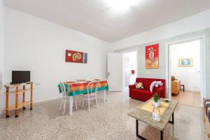 un soggiorno con divano rosso e tavolo di Casa di Emanuela a San Foca