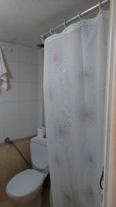 y baño con aseo y cortina de ducha. en LENIA, en Nea Plagia