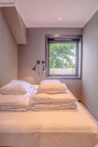 Cette chambre comprend un lit avec deux oreillers et une fenêtre. dans l'établissement Near Brosundet, Newly Refurnished, Free Street Parking, à Ålesund