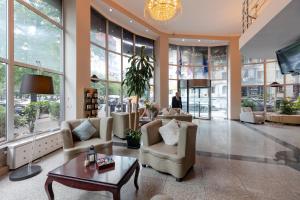 a lobby with chairs and a table in a building at Hotel Aisi in Batumi