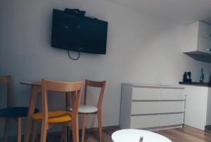 two chairs and a table with a television on a wall at Apartamenty w Pieninach in Sromowce Wyżne