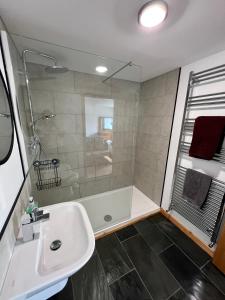 a bathroom with a tub and a sink and a shower at Barty’s Bothy in Contin