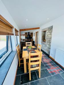 a kitchen and dining room with a table and chairs at Barty’s Bothy in Contin