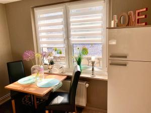 a kitchen with a table and a refrigerator and a window at Ferienhaus am Schloßpark in Elbingerode
