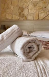a white towel sitting on top of a bed at VILLA MARIA ELENA Charme Rooms sul mare in Capo Vaticano +56 photos