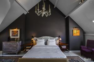 a bedroom with a large bed and a chandelier at B&B Huyze Elimonica in Ostend