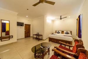 a bedroom with a bed and a living room at Yellow Residency in Puducherry