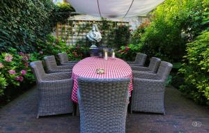 une table avec des chaises en osier et un tissu de table rouge et blanc dans l'établissement B&B Huyze Elimonica, à Ostende