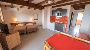 a small room with two beds and a kitchen at Le California Motel in Sagone