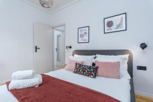 a bedroom with a white bed with pink pillows at Zeus 2-Bedroom Apartment in Athens in Athens