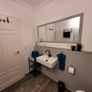 een badkamer met een witte wastafel en een spiegel bij Ferienwohnung Abendsonne in Zarrentin