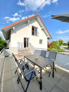 a table and chairs on the roof of a house at Modernes 3-Familienhaus im Allgäu in Erkheim