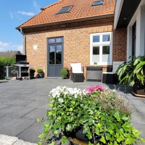 a house with a patio with flowers in front of it at Ferienwohnung Abendsonne in Zarrentin